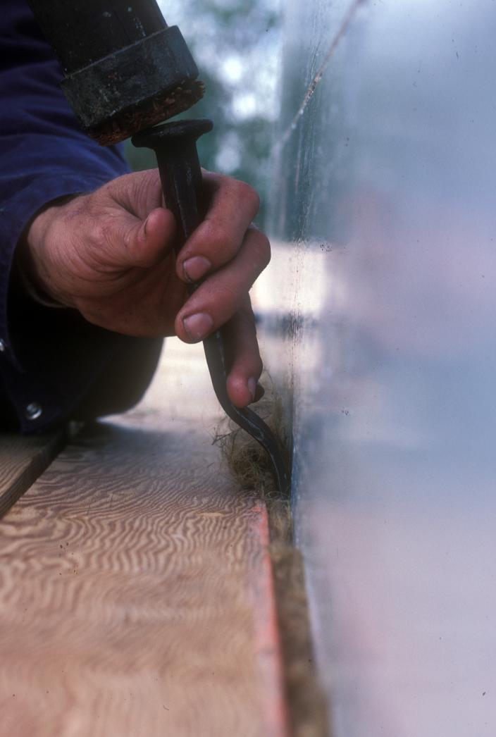 Caulking during restoration of Trixen, c. 1986. 